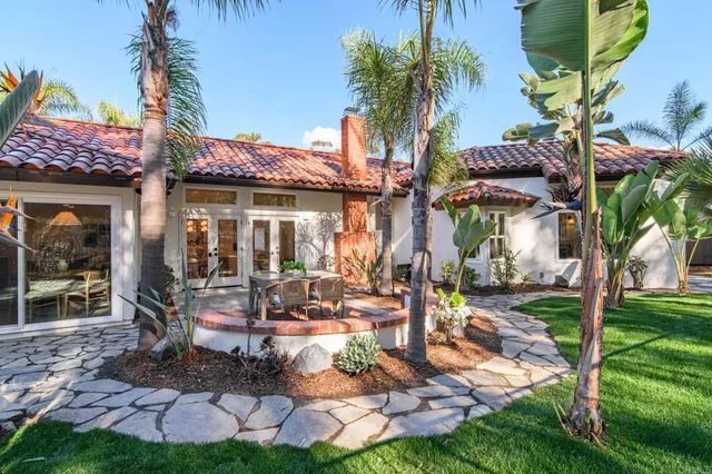 a patio with table and chairs and potted plants