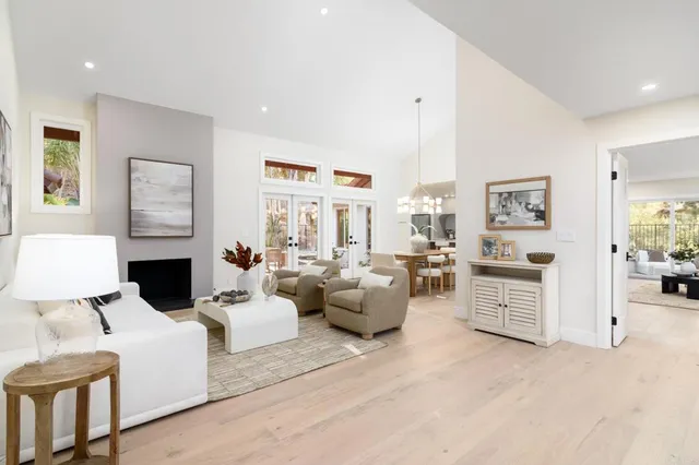 a living room with furniture large window and fireplace