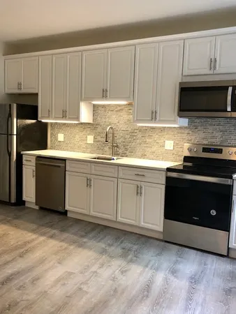 a kitchen with stainless steel appliances granite countertop a stove a sink and a microwave