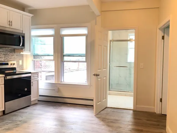 a view of a kitchen with wooden floor and a window