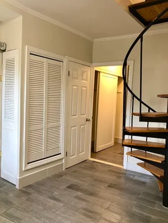a view of front door with wooden floor and stairs