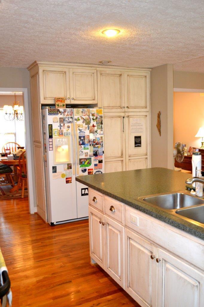 2588 Iron Ridge Road Rocky Mount, VA 24151 - Photo 26 of 65 a kitchen with granite countertop a refrigerator a sink and white cabinets