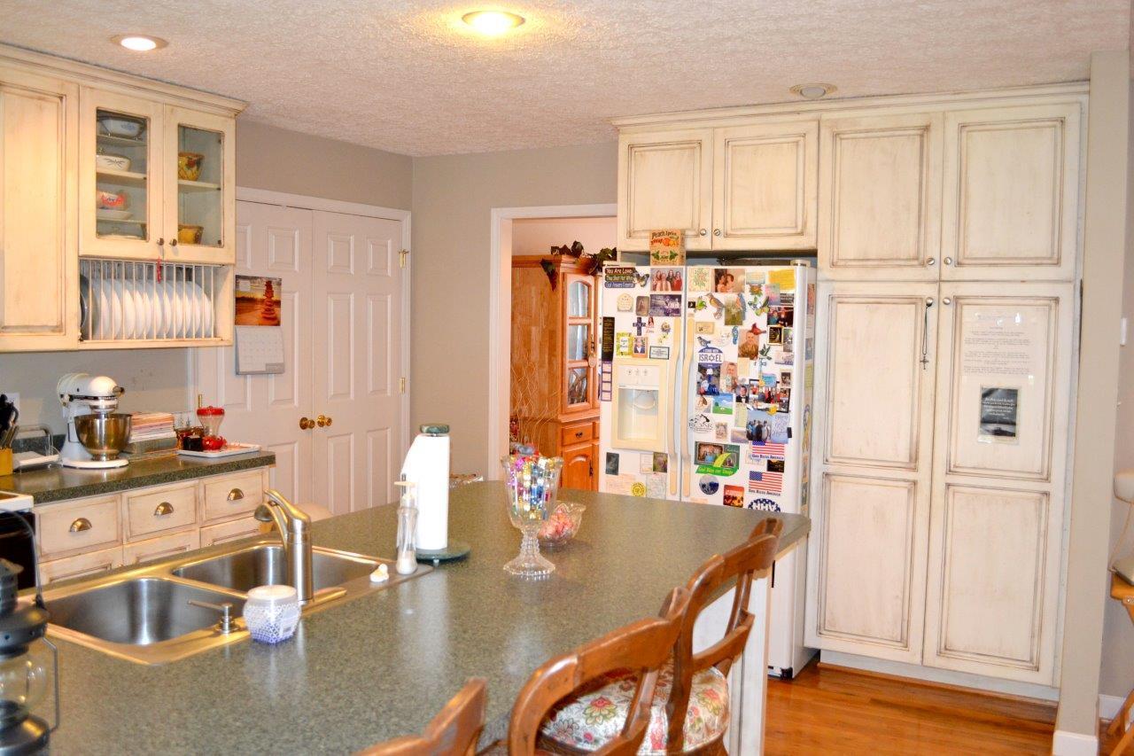 2588 Iron Ridge Road Rocky Mount, VA 24151 - Photo 31 of 65 a kitchen with stainless steel appliances granite countertop a refrigerator a sink dishwasher and white cabinets with wooden floor