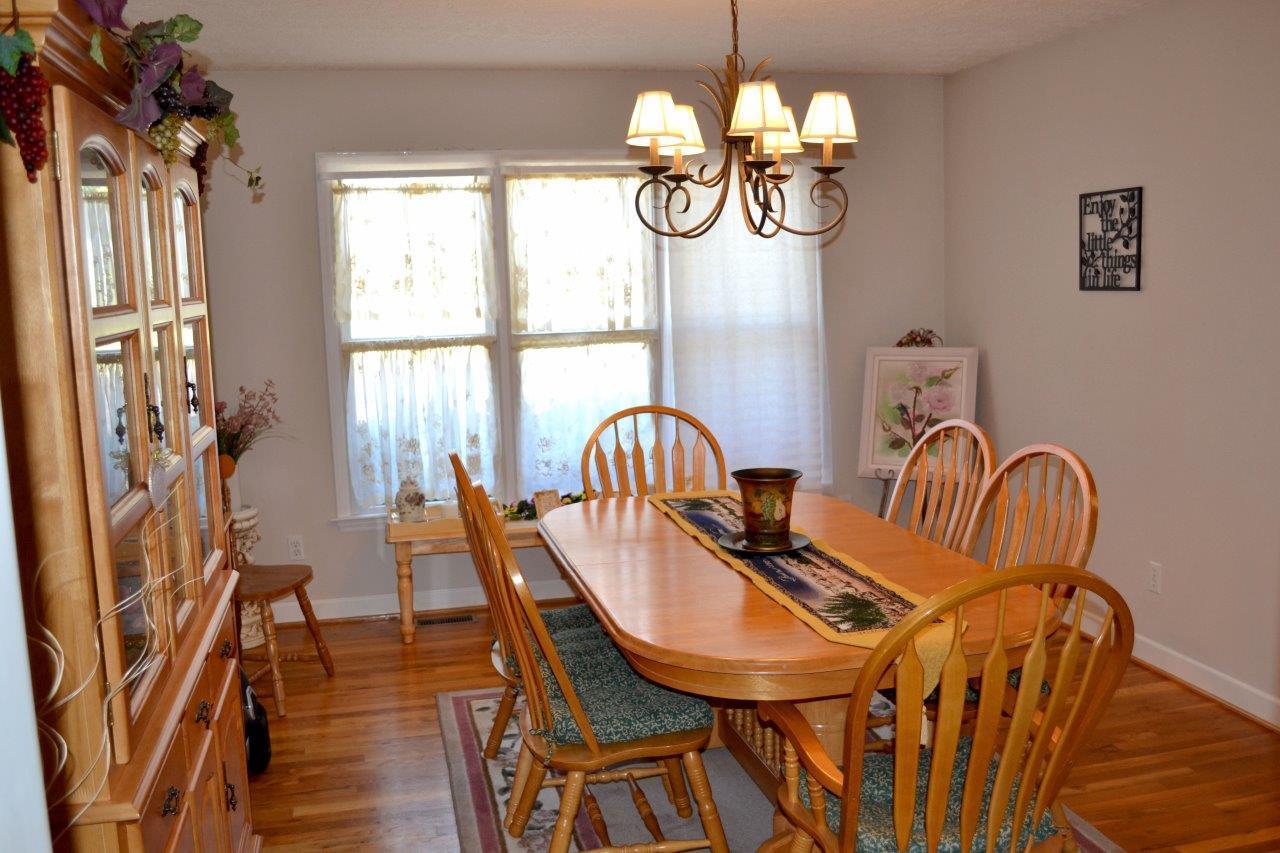 2588 Iron Ridge Road Rocky Mount, VA 24151 - Photo 32 of 65 a view of a dining room with furniture a chandelier and wooden floor