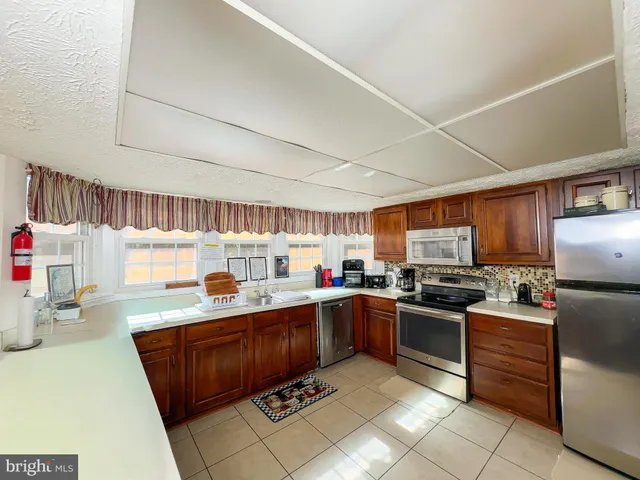 a kitchen with stainless steel appliances granite countertop a sink dishwasher stove top oven and refrigerator