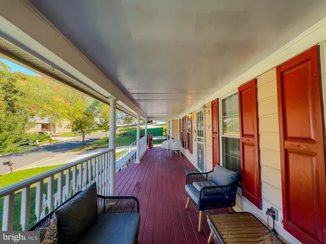 a view of a porch with furniture and wooden floor