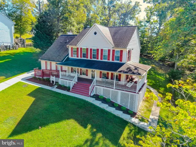 an aerial view of a house with a big yard potted plants and large tree