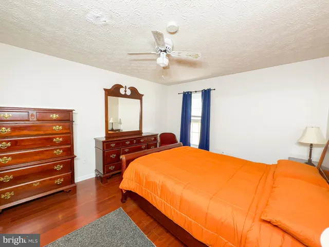 a bedroom with a bed and dresser with mirror