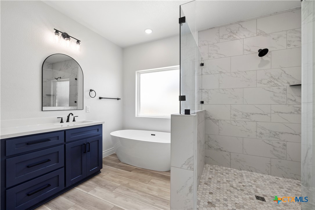 1823 Ember Drive Temple, TX 76502 - Photo 22 of 46 a spacious bathroom with a double vanity sink a large mirror and shower