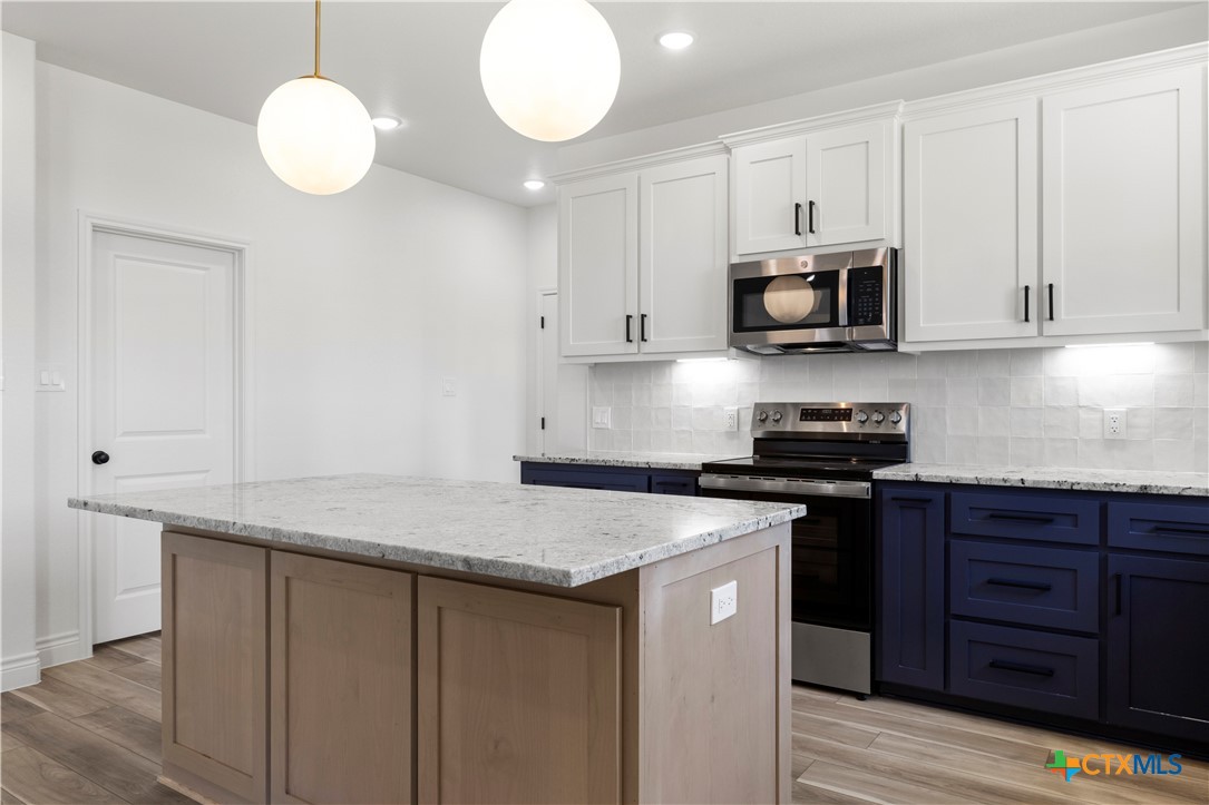 1823 Ember Drive Temple, TX 76502 - Photo 7 of 46 a kitchen with stainless steel appliances granite countertop a sink dishwasher a stove and a microwave oven on granite countertops
