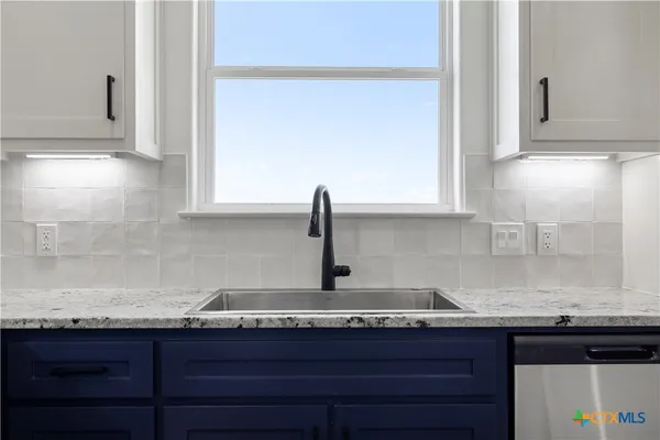 a kitchen with granite countertop a sink and cabinets