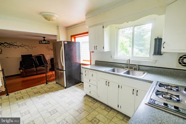 a kitchen that has a sink a stove and a refrigerator