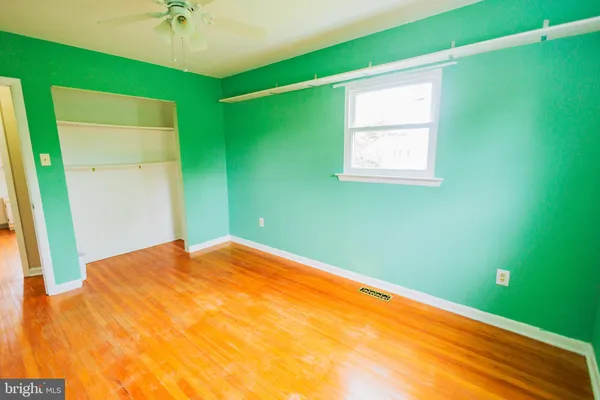 a view of a big room with a ceiling fan and a window