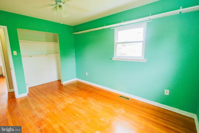 a view of a big room with a ceiling fan and a window