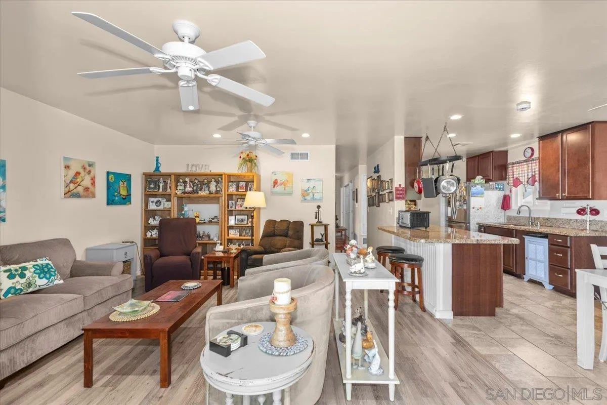 9254 Shadow Hill Road Santee, CA 92071 - Photo 17 of 34 a living room with lots of furniture kitchen view and a chandelier