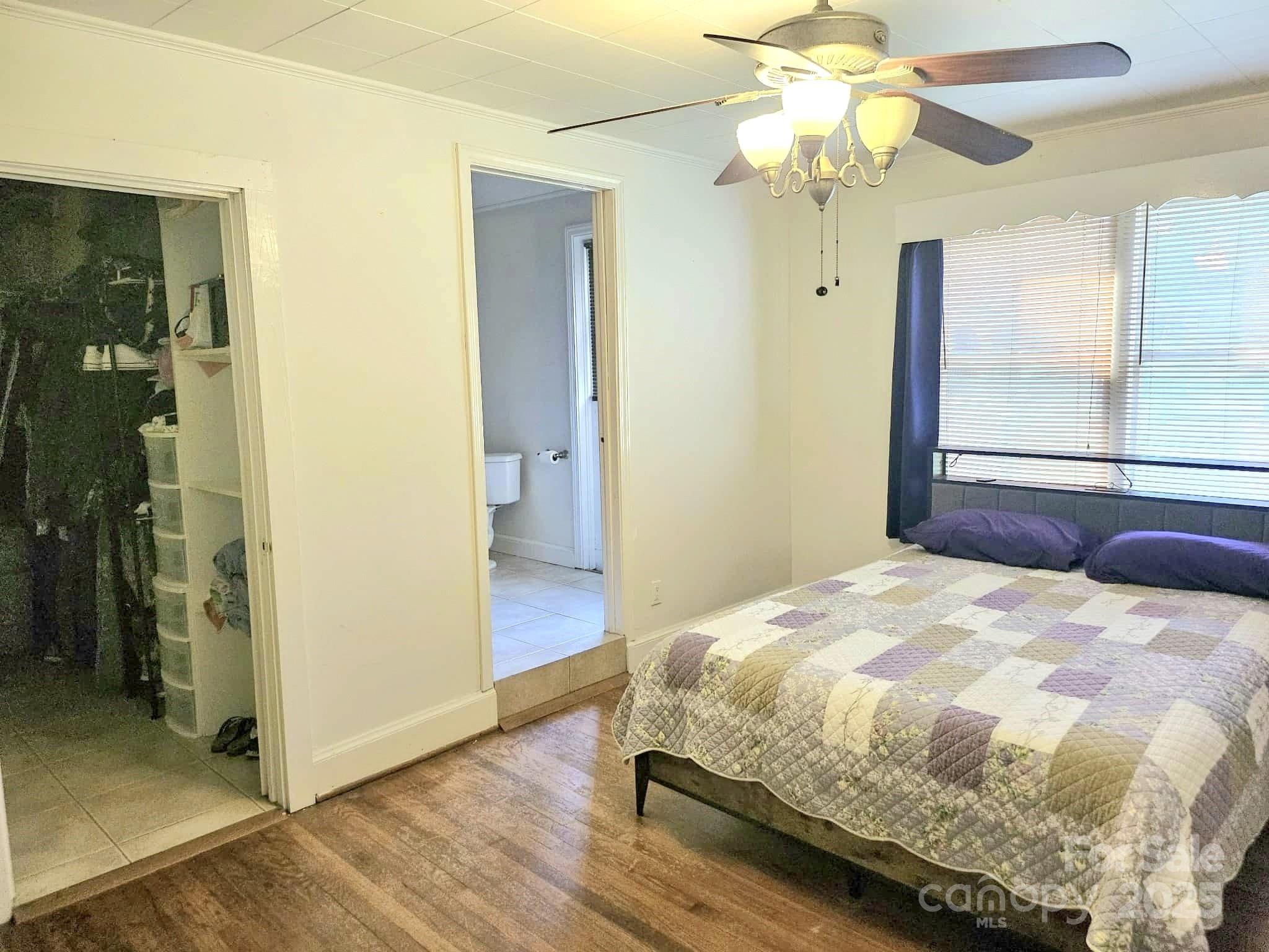 3744 Hunting Country Road Tryon, NC 28782 - Photo 14 of 34 a bedroom with a bed and a chandelier