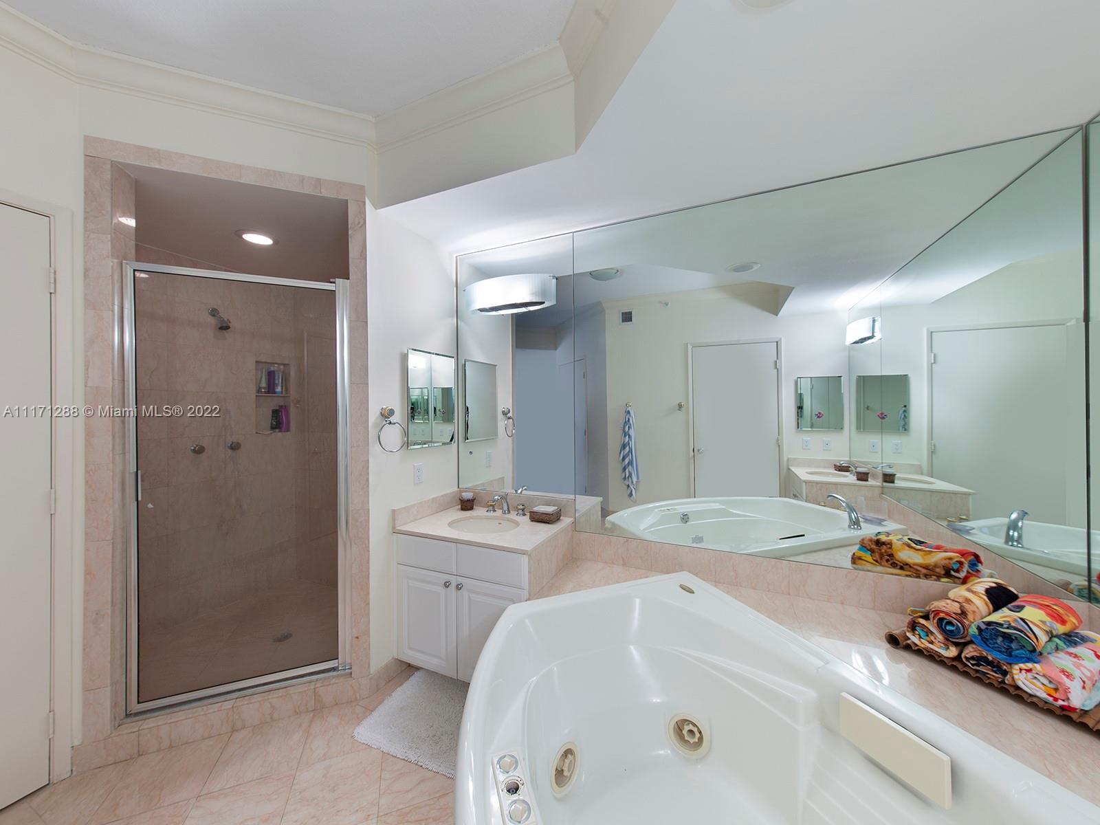 735 Crandon Boulevard, Unit 503 Key Biscayne, FL 33149 - Photo 13 of 18 a spacious bathroom with a tub sink shower and mirror