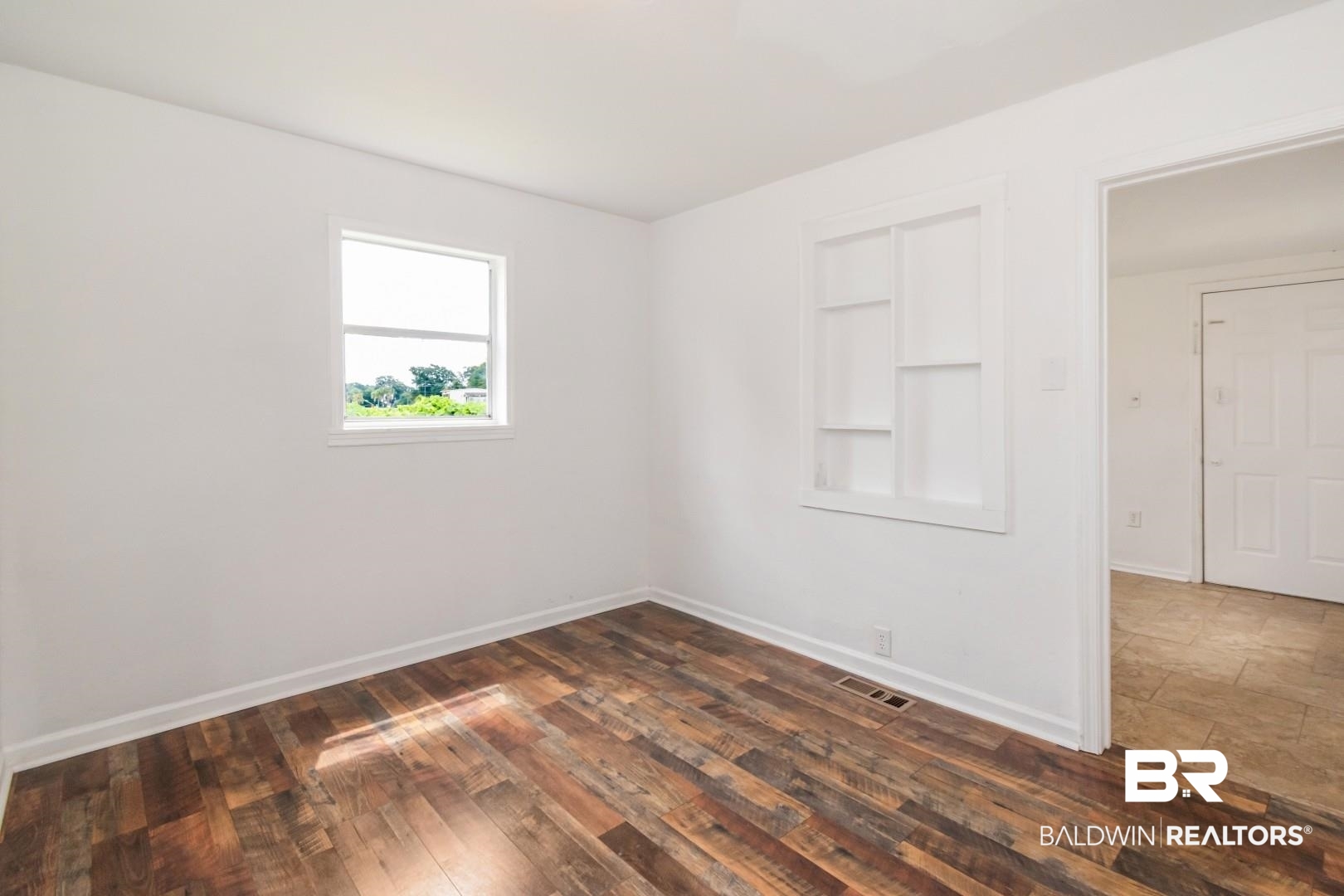 2905A McFarland Road, Unit F Mobile, AL 36695 - Photo 18 of 29 Room featuring wood-finish flooring, white walls, and a built-in wall niche with shelving