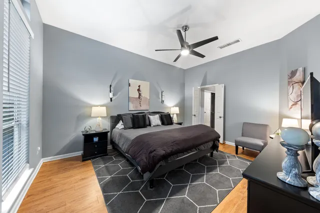 a bedroom with a bed and a mirror on the dresser