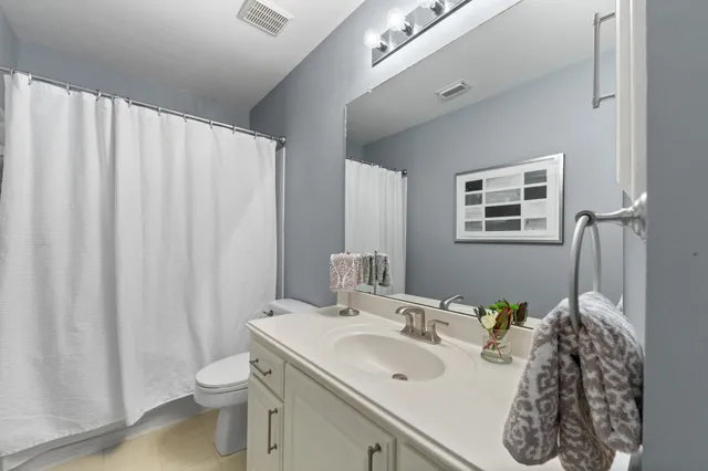 a bathroom with a sink a toilet and shower curtain