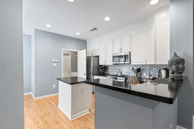 a kitchen with stainless steel appliances granite countertop a sink and cabinets