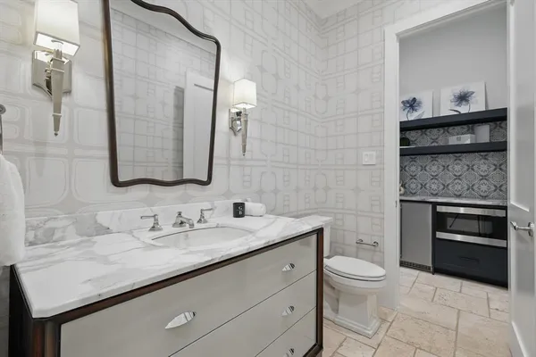 a bathroom with a granite countertop sink a toilet and a mirror
