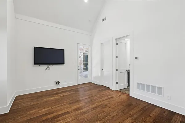 a view of a livingroom with wooden floor and flat screen tv