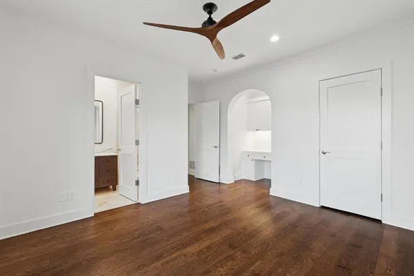 an empty room with wooden floor and mirror