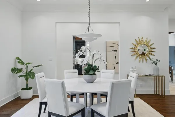 a dining room with furniture potted plants and wooden floor