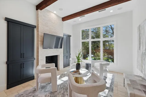 a living room with furniture a fireplace and a large window