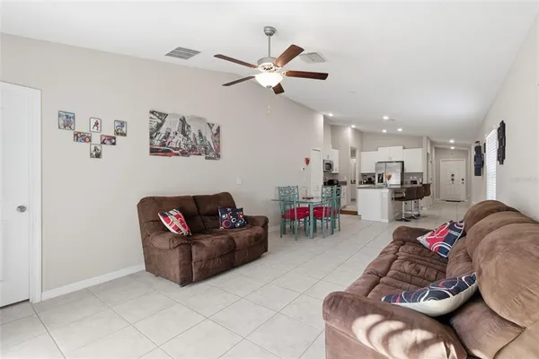 a living room with furniture and kitchen view