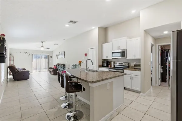 a kitchen with stainless steel appliances kitchen island granite countertop a sink and cabinets