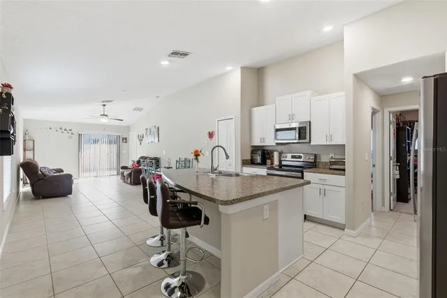 a kitchen with stainless steel appliances kitchen island granite countertop a sink and cabinets