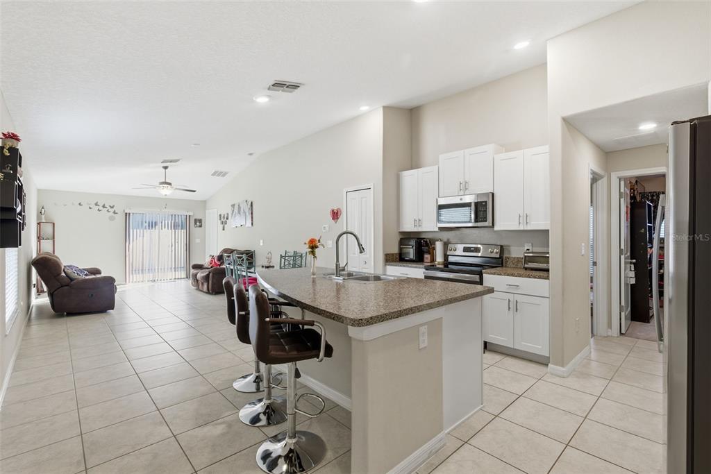 10239 Bright Crystal Avenue Riverview, FL 33578 - Photo 29 of 47 a kitchen with stainless steel appliances kitchen island granite countertop a sink and cabinets