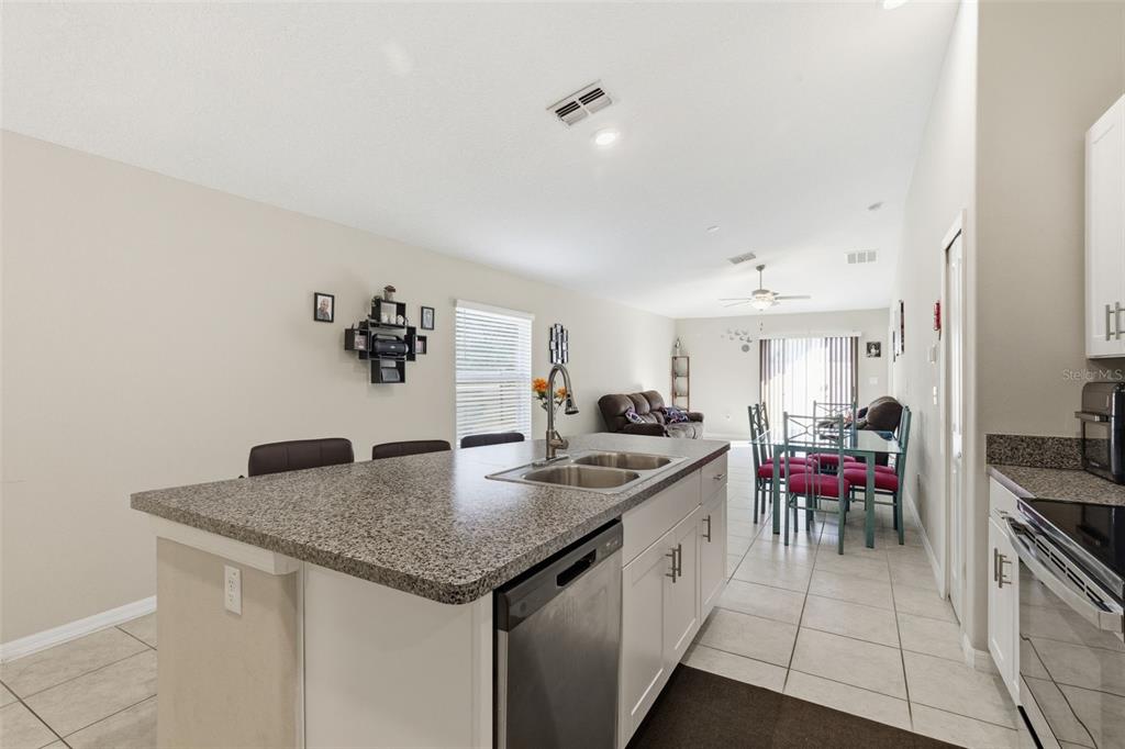 10239 Bright Crystal Avenue Riverview, FL 33578 - Photo 32 of 47 a kitchen with a stove and a refrigerator