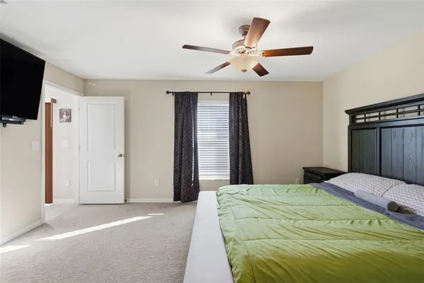 a bedroom with a large bed and a flat screen tv