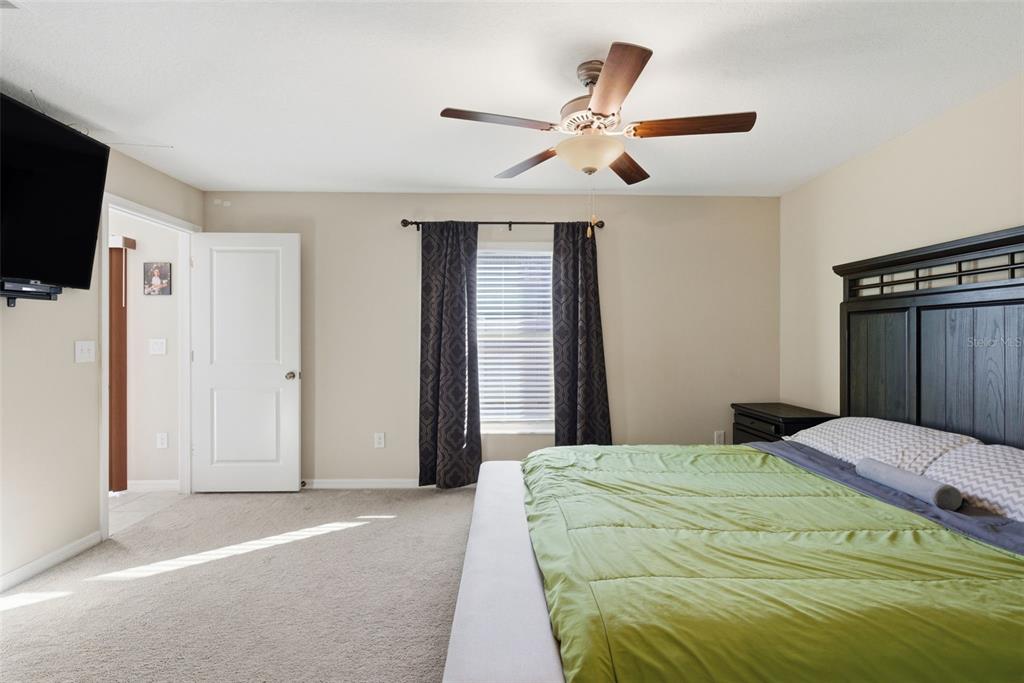 10239 Bright Crystal Avenue Riverview, FL 33578 - Photo 40 of 47 a bedroom with a large bed and a flat screen tv