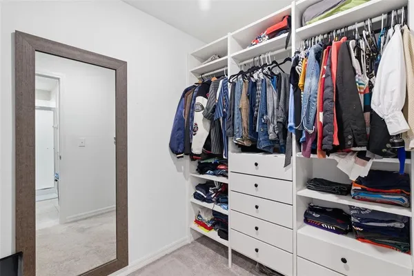 a view of walk in closet with clothes