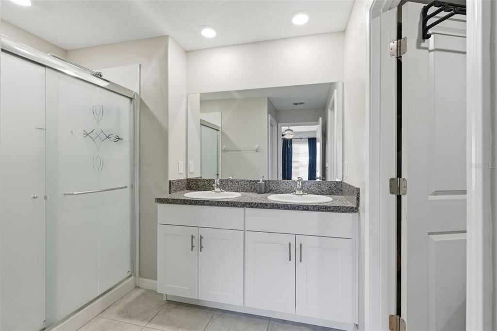 10239 Bright Crystal Avenue Riverview, FL 33578 - Photo 44 of 47 a bathroom with a granite countertop shower sink and mirror