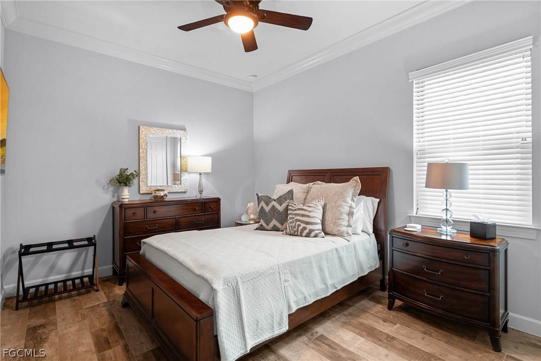 9383 Slate Court Naples, FL 34120 - Photo 16 of 28 a bedroom with bed and a chandelier