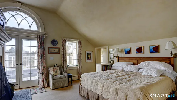 a bedroom with a bed and a large window