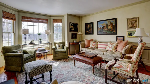 a living room with furniture and a floor to ceiling window
