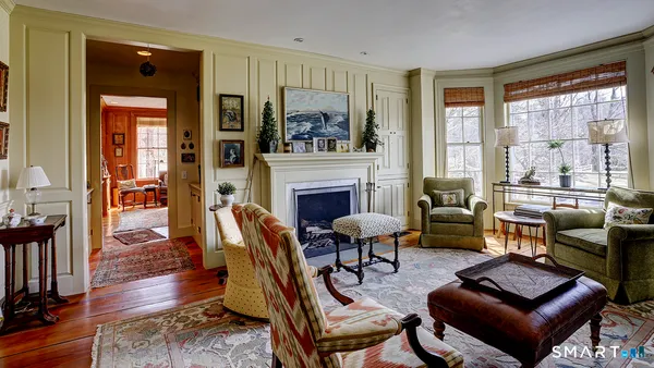 a living room with furniture fireplace and a large window