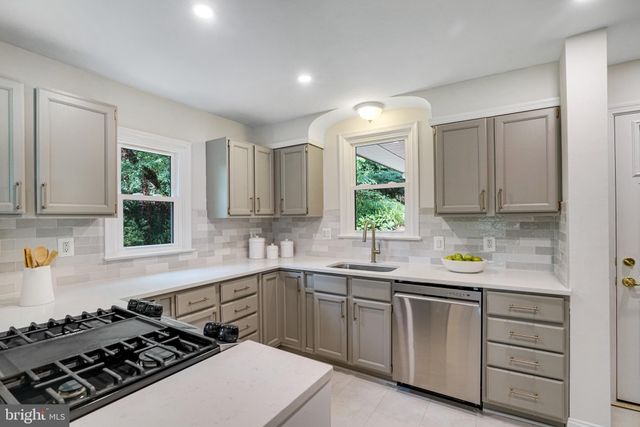 a kitchen with sink a stove and cabinets