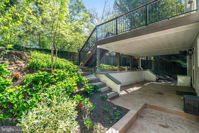 a view of a patio with table and chairs potted plants with wooden floor and fence