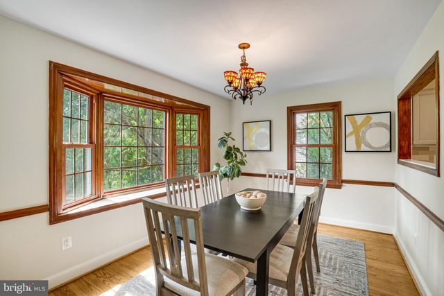 a view of a dining room with furniture a chandelier and wooden floor