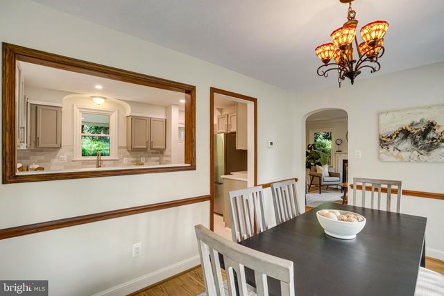 a view of a dining room with furniture a chandelier and wooden floor