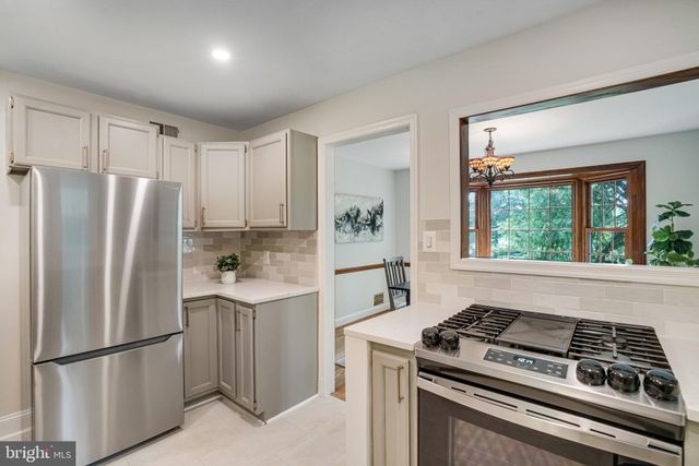 a kitchen with a stove a refrigerator and a window