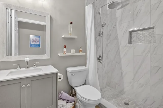 a living room with furniture and a open kitchen view