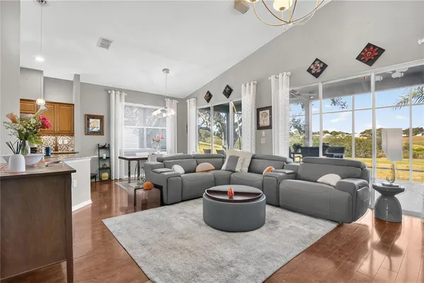 a living room with furniture kitchen and a chandelier